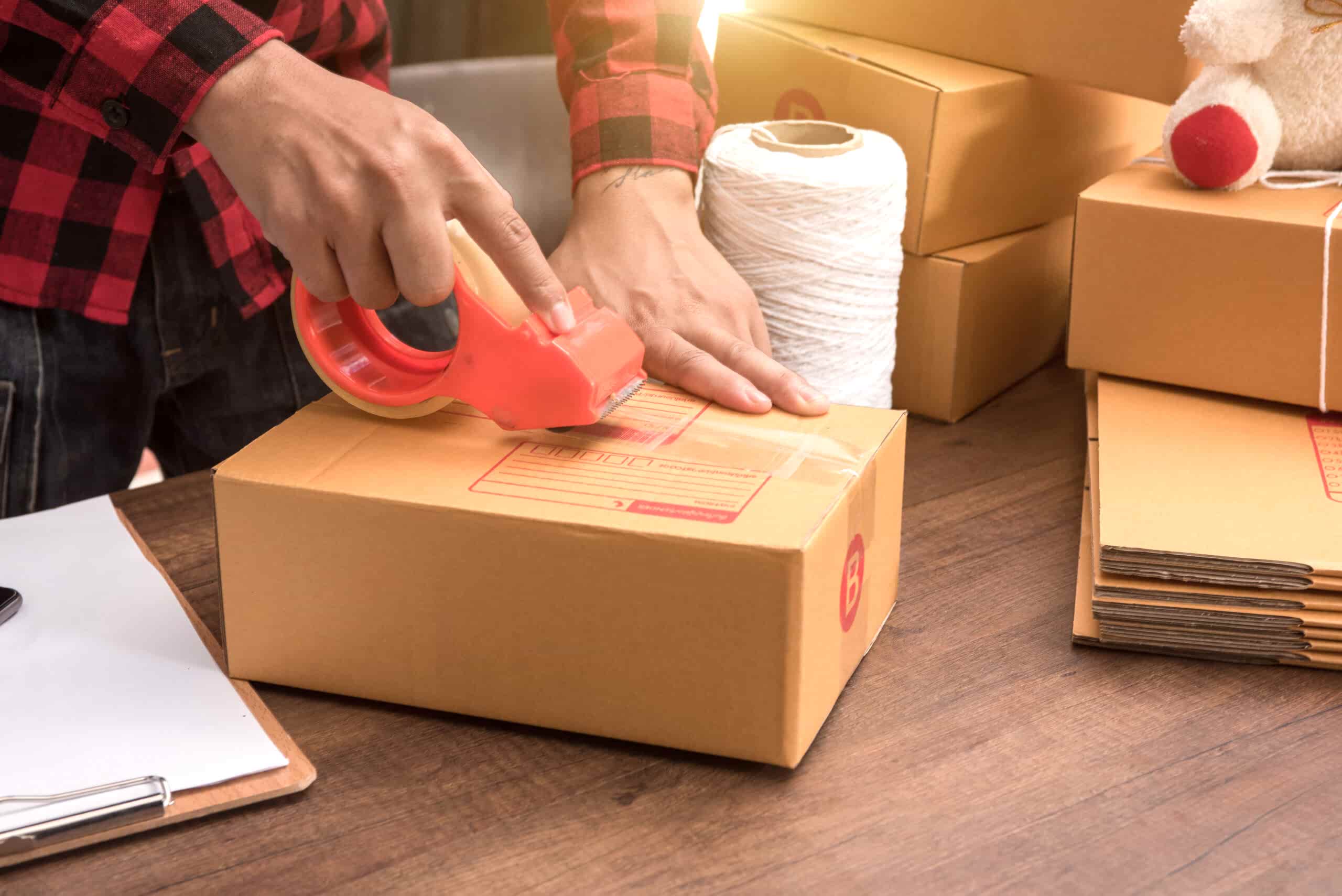 young-hand-woman-prepareing-package-be-sent-wooden-floor-scaled